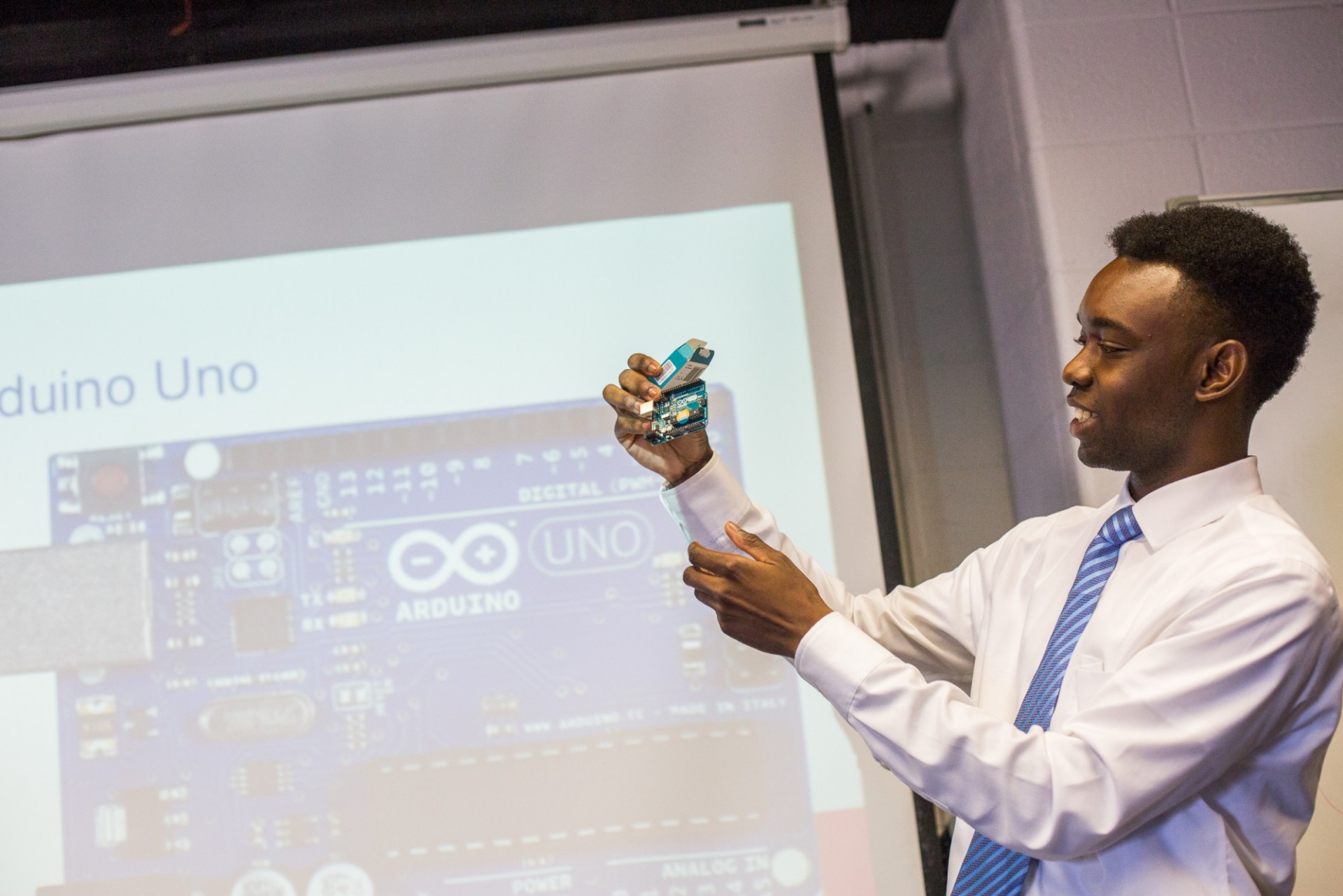 A student holds up an arduino used in his final presentation of research. Photo Credit: Tim Lee LaGuardia Community College Research Program