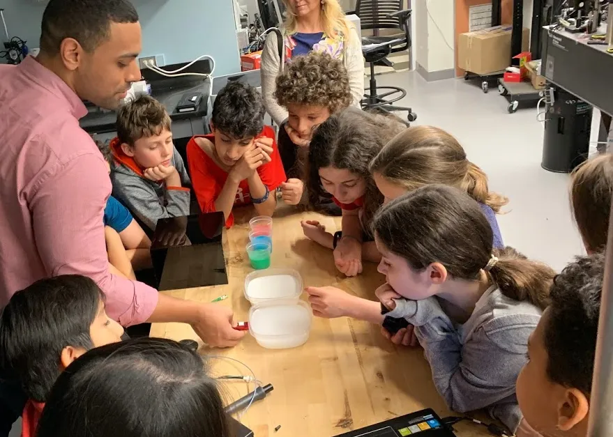 Students explore optics with a graduate student from Professor Christine Hendon's lab.